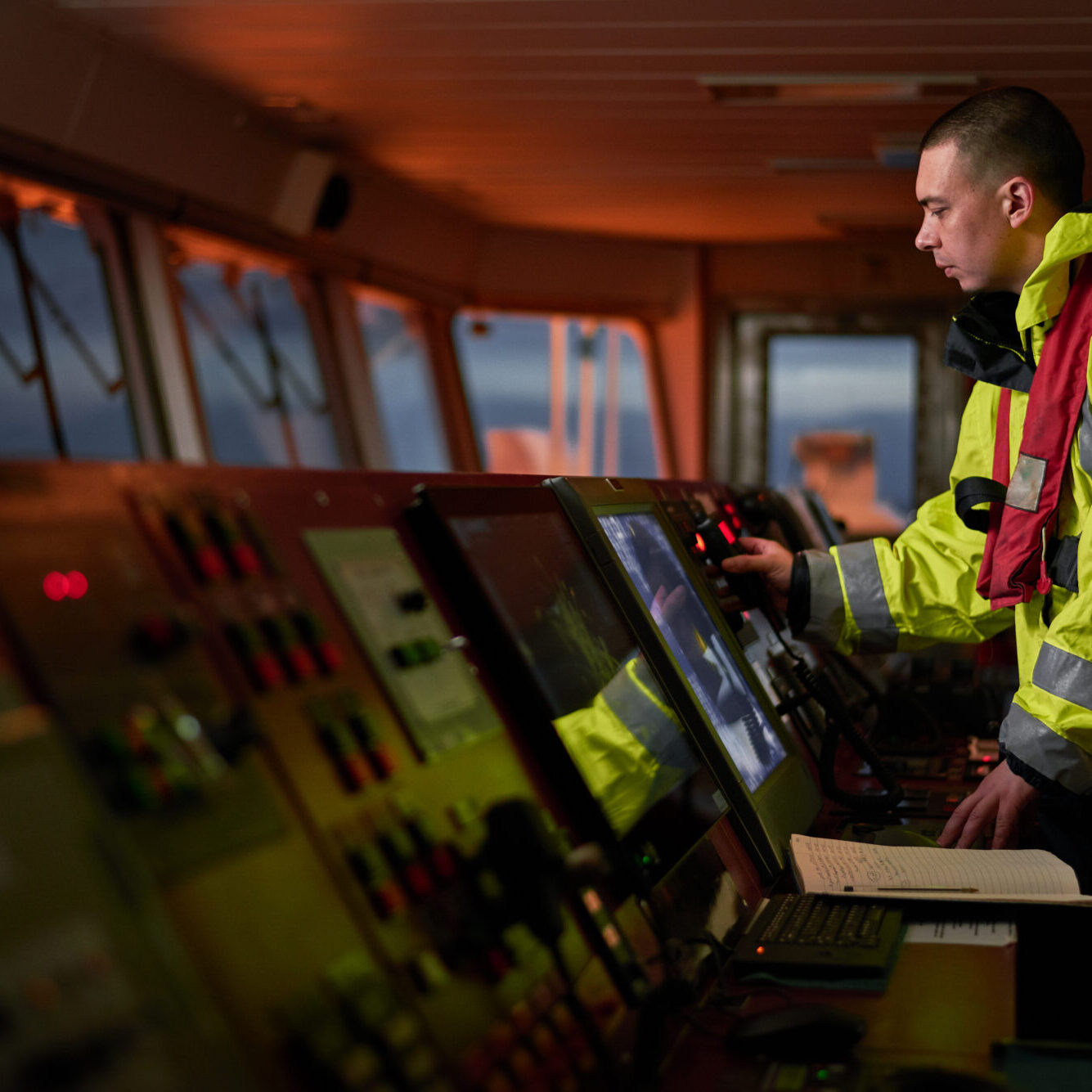 Navigator. pilot, captain as pat of ship crew performing daily duties with VHF radio, binoculars, logbook, standing nearby to ECDIS and radar station on board of modern ship with high quality navigation equipment on the bridge. Great design for navigation, safety of shipping, cargo carriage puproses.